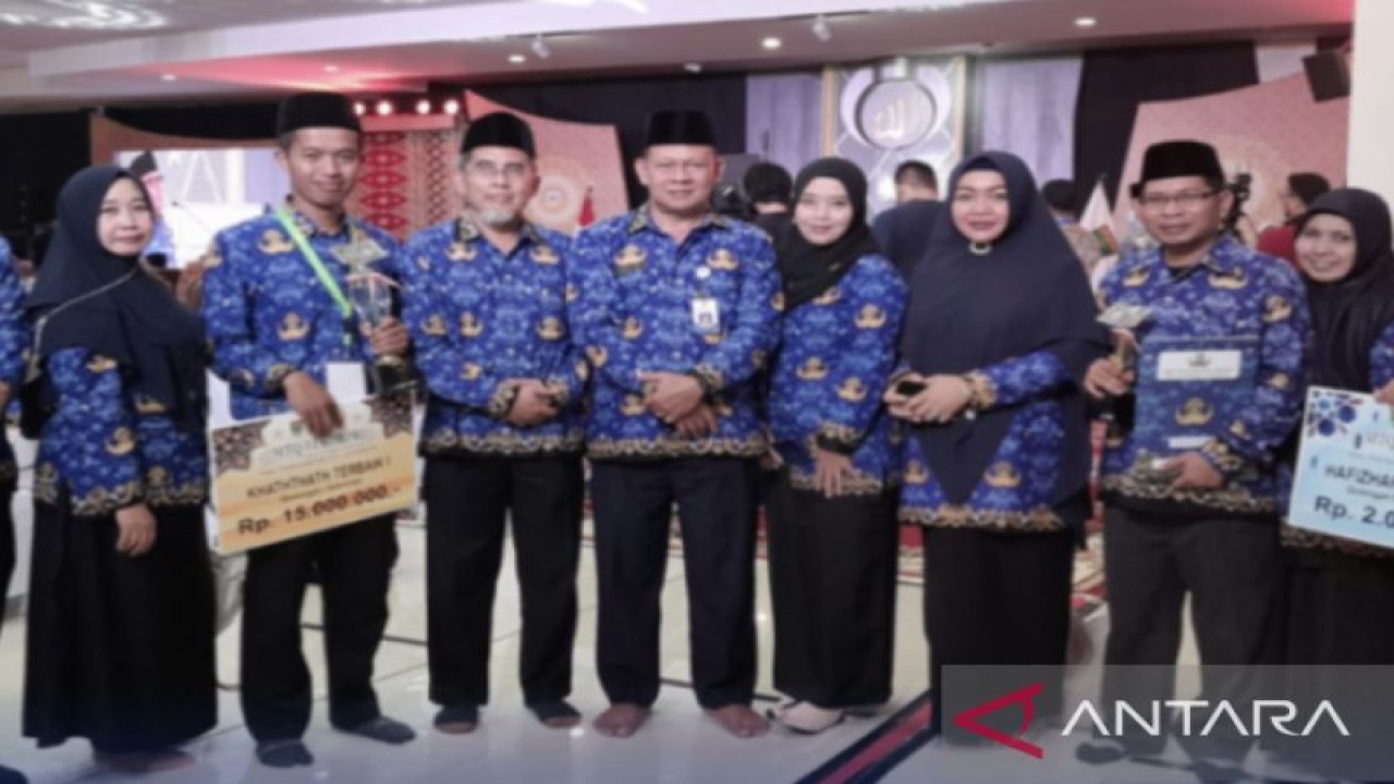 Kholis peraih juara pertama kaligrafi pada MTQ VI KORPRI Tingkat Nasional di Sumatera Barat, didampingi offficial tim Korpri Kaltim. (Diskominfo Kaltim)