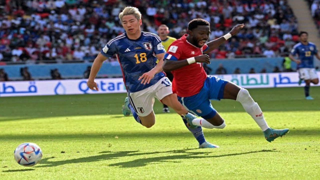 Penyerang Jepang Takano Asano (kiri) berebut bola dengan bek Kosta Rika Keysher Fuller pada pertandingan Grup E Piala Dunia 2022 di Stadion Ahmed bin Ali, Al Rayyan, Qatar, Minggu. (27/11/2022) (AFP/ANNE-CHRISTINE POUJOULAT)