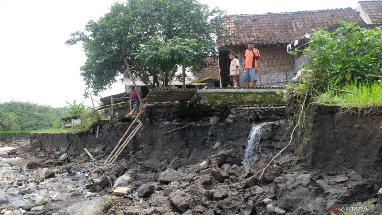 Warga menyaksikan lokasi bencana tebing longsor di tepi sungai Progo di Dusun Ngiwon, Banyuwangi, Bandongan, Magelang, Jawa Tengah, Sabtu (22/10/2022). Banjir besar pada Jumat (21/10/2022) mengakibatkan tebing sungai sepanjang 300 meter dengan lebar 10 meter ambrol sehingga mengancam keberadaan belasan rumah warga yang berada di bantaran sungai. ANTARA FOTO/Anis Efizudin/aww (ANTARA FOTO/ANIS EFIZUDIN)