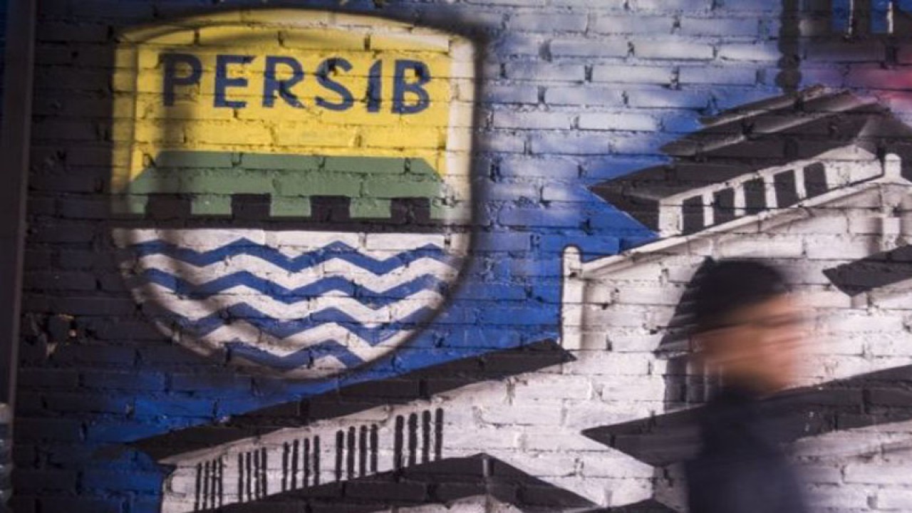 Seorang bobotoh alias pendukung Persib berjalan di depan mural Persib di Bandung, Jawa Barat, Selasa (2/10/2018). (ANTARA FOTO/Novrian Arbi/wsj)