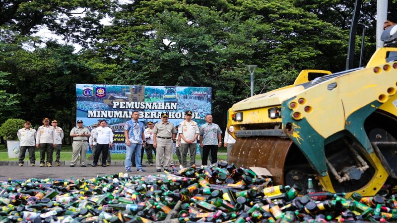 Petugas menggunakan alat berat memusnahkan belasan ribu botol minuman keras di Monas, Jakarta, Jumat (18/11/2022). ANTARA/HO-Pemprov DKI