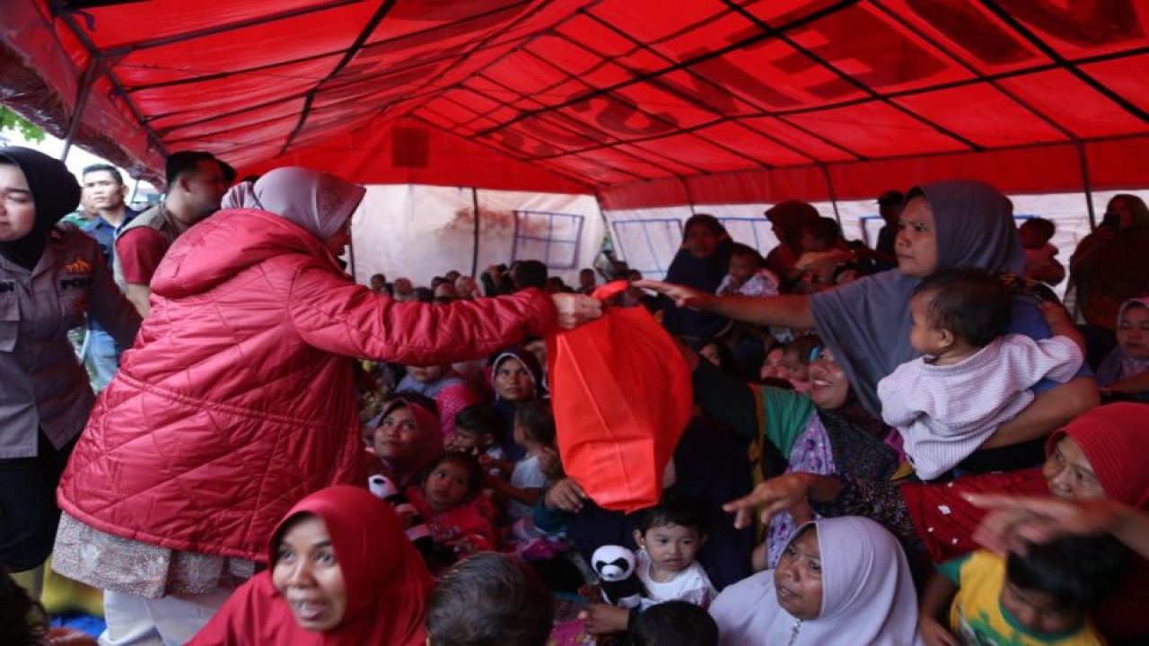 Menteri Sosial Tri Rismaharini (kiri) menyerahkan kebutuhan para pengungsi korban banjir di Kabupaten Aceh Tamiang, Provinsi Aceh, Rabu (9/11/2022).(ANTARA/HO-Kemensos)
