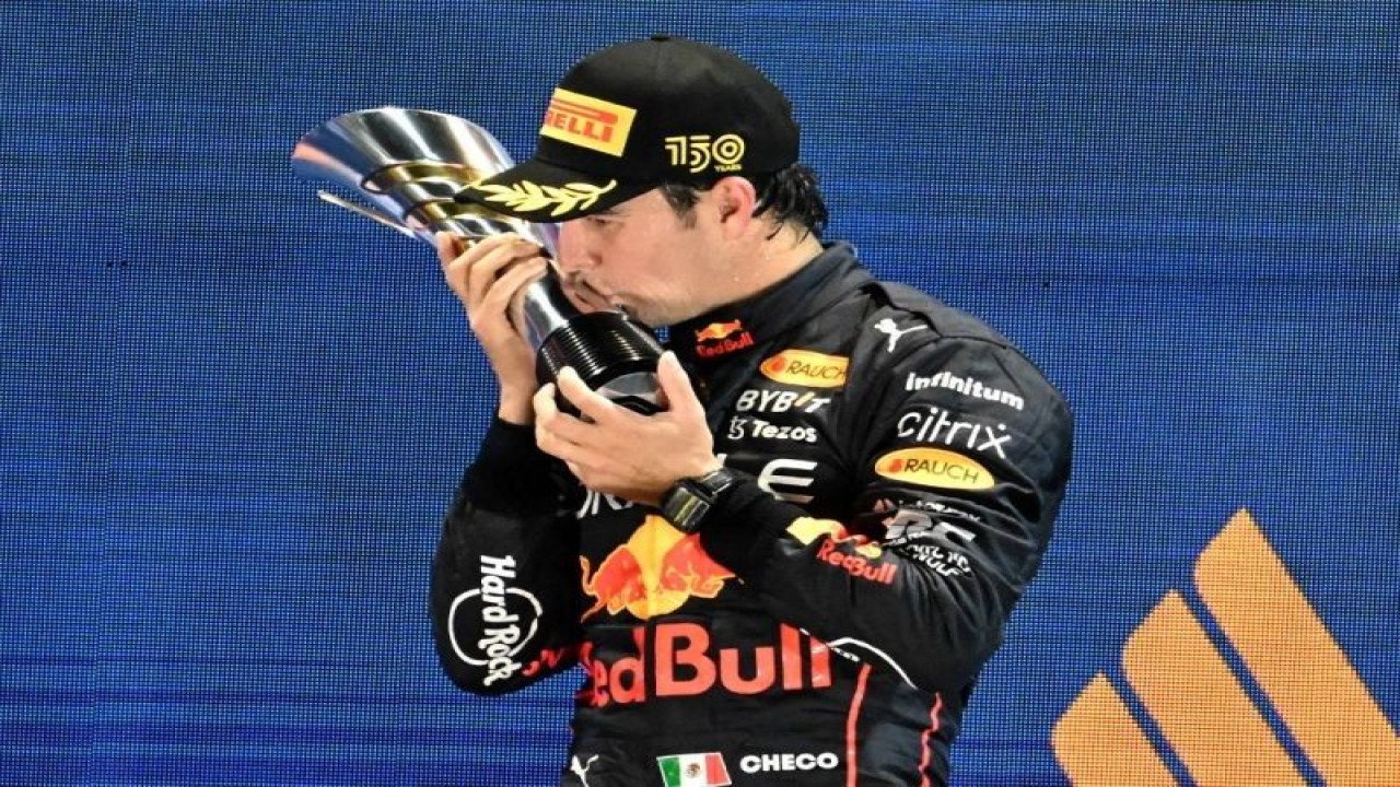 Pebalap tim Red Bull Sergio Perez melakukan selebrasi setelah memenangi Grand Prix Singapura di Sirkuit Marina Bay, Minggu (2/10/2022). (ANTARA/AFP/ROSLAN RAHMAN.)