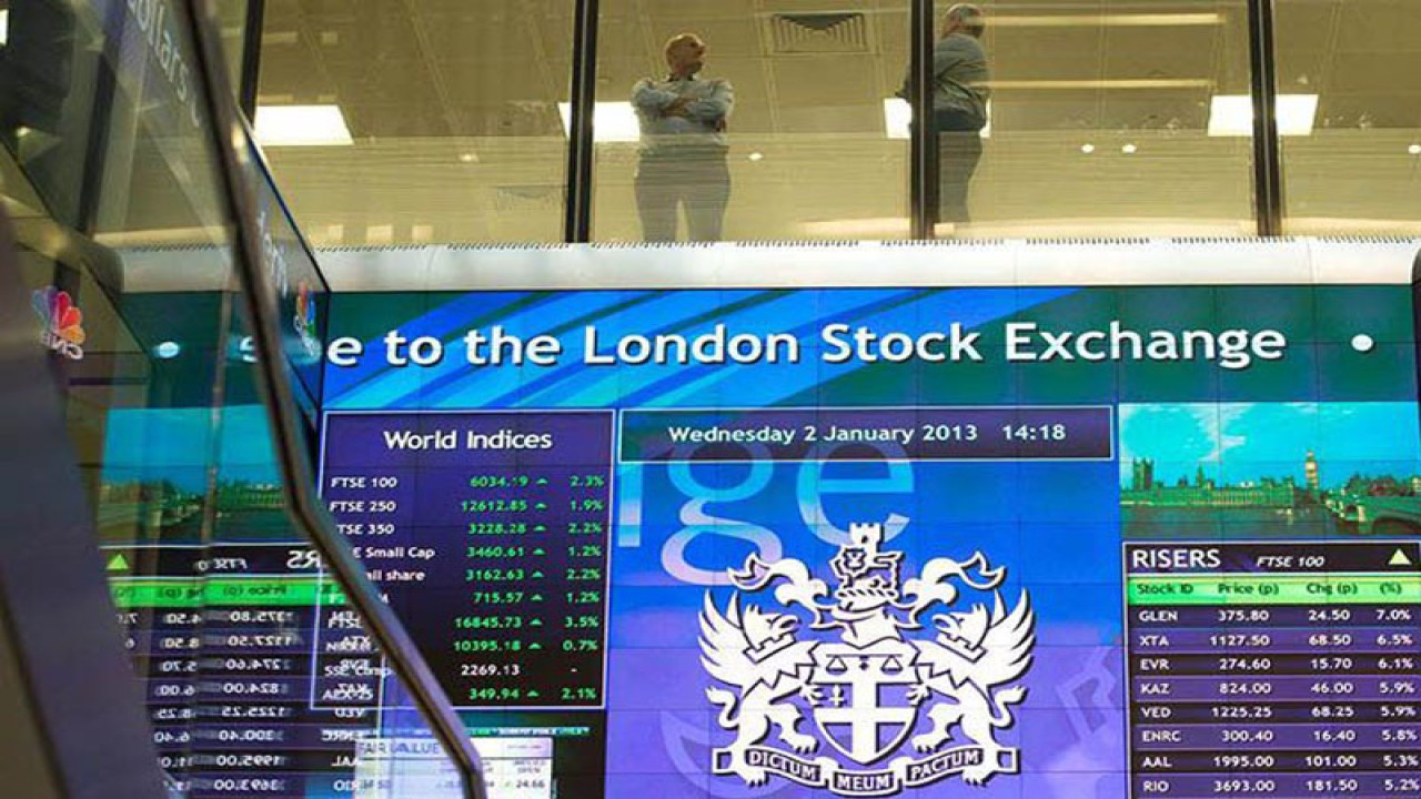Pekerja terlihat berbincang di atas papan elektronik pergerakan saham di London Stock Exchange, Inggris. REUTERS/Paul Hackett/aa.