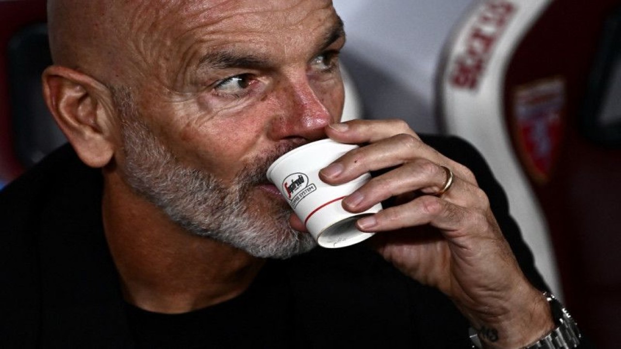 Pelatih kepala AC Milan Stefano Pioli meminum kopi sebelum pertandingan Serie A Italia antara Torino dan AC Milan di Stadion Grande Torino di Turin pada 30 Oktober 2022. (AFP/MARCO BERTORELLO)