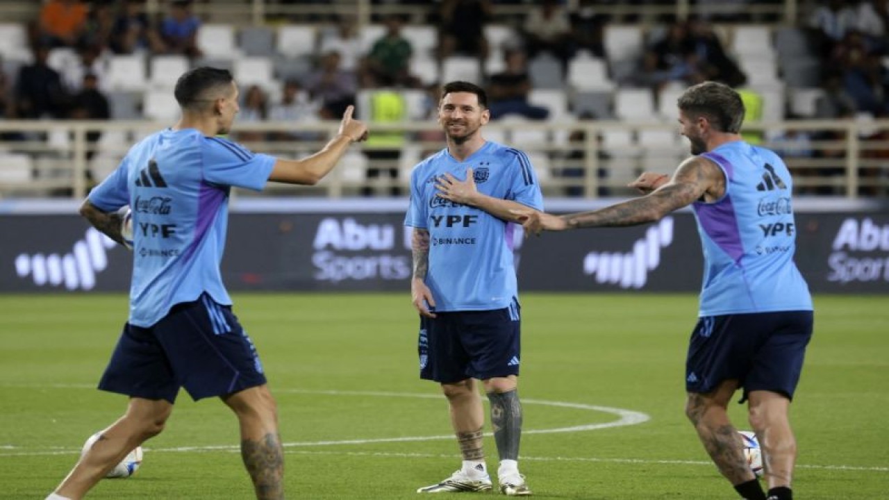 Pemain timnas Argentina Angel Di Maria (kiri), Lionel Messi (tengah) dan Rodrigo de Paul (kanan) menjalani pemusatan latihan di Nahyan Stadium Abu Dhabi, Uni Emirat Arab, 14 November 2022 menjelang Piala Dunia 2022. (AFP/KARIM SAHIB)