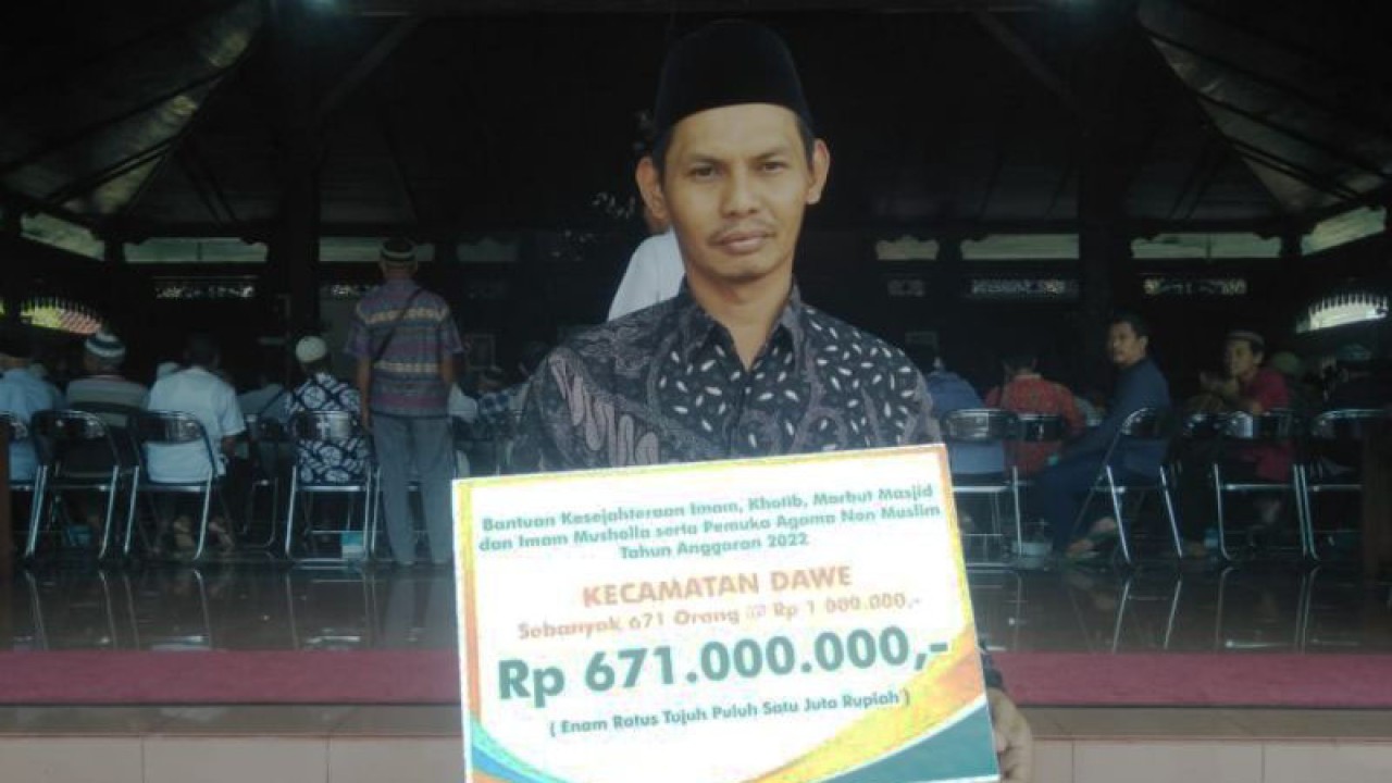 Salah seorang penerima bantuan kesejahteraan dari Pemkab Kudus menunjukkan plakat bantuan yang diterima dari Bupati Kudus Hartopo di Pendopo Kabupaten Kudus, Kamis (24/11/2022). ANTARA/Akhmad Nazaruddin Lathif.