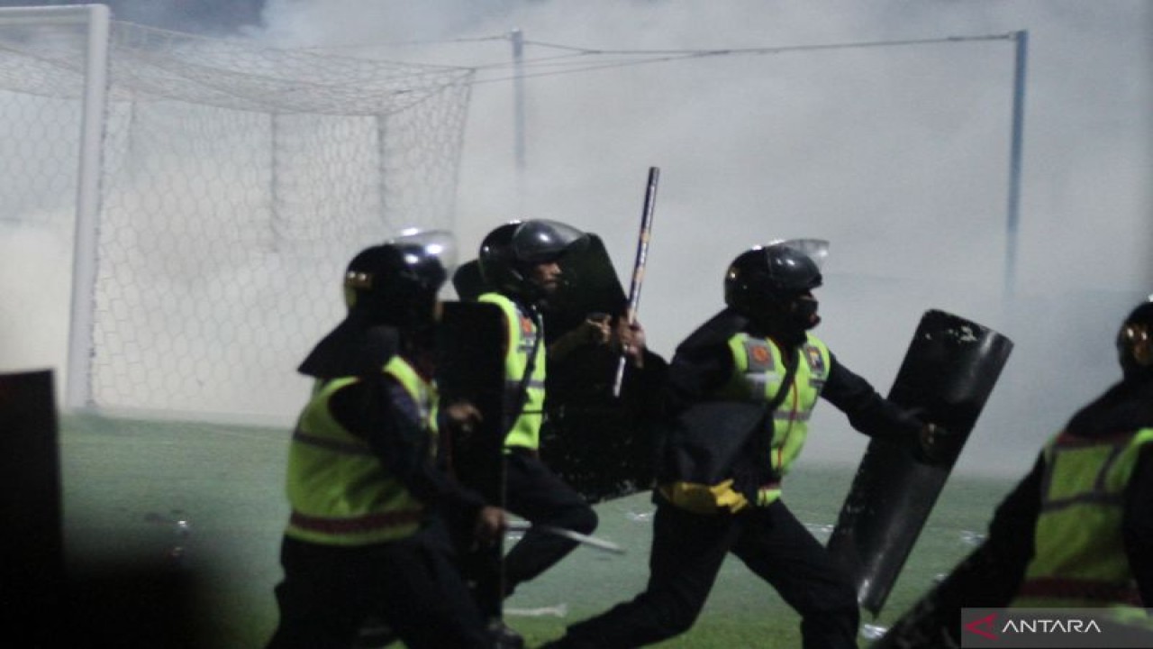 Aparat keamanan berusaha menghalau suporter yang masuk ke lapangan usai pertandingan BRI Liga 1 antara Arema melawan Persebaya di Stadion Kanjuruhan, Malang, Jawa Timur, Sabtu malam (1/10/2022). (ANTARA FOTO/Ari Bowo Sucipto/foc.)