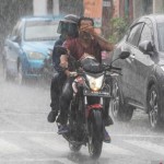 Pengendara sepeda motor menerobos hujan di kawasan Alun-alun Selatan, Yogyakarta,-1668072628