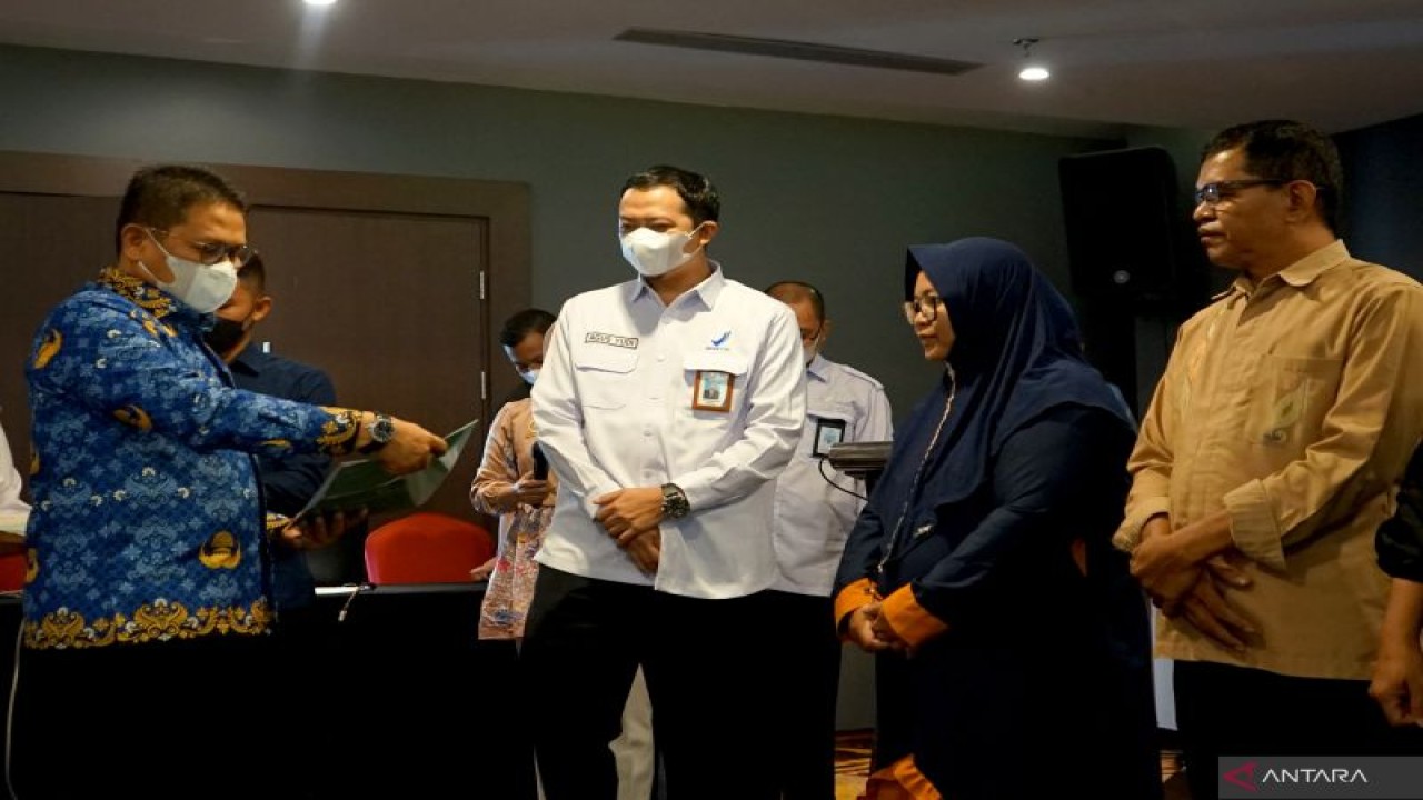 Penjabat Gubernur Gorontalo Hamka Hendra Noer (kiri) didampingi Kepala Badan Pengawas Obat dan Makanan (BPOM) Gorontalo Agus Yudi Prayudana (kedua kiri) menyerahkan surat izin edar kepada pelaku UMKM pangan olahan di Kota Gorontalo, Gorontalo, Kamis (17/11/2022). ANTARA/Adiwinata Solihin