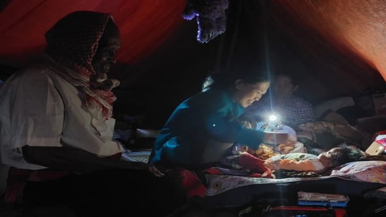 Seorang Ibu bermain dengan anak bayi dengan penerangan lampu ponsel di tenda pengungsian gempa Kampung Babakan Imbangan, Desa Cibulakan Kecamatan Cugenang, Kabupaten Cianjur, Jawa Barat, Rabu (24/11/2022). ANTARA/Erlangga BP