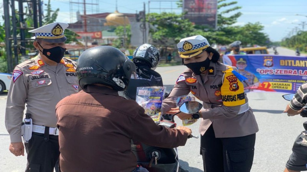 Personel Polda Riau memberikan edukasi kepada masyarakat terkait keselamatan di jalan belum lama ini. (ANTARA/HO-Polda Riau)