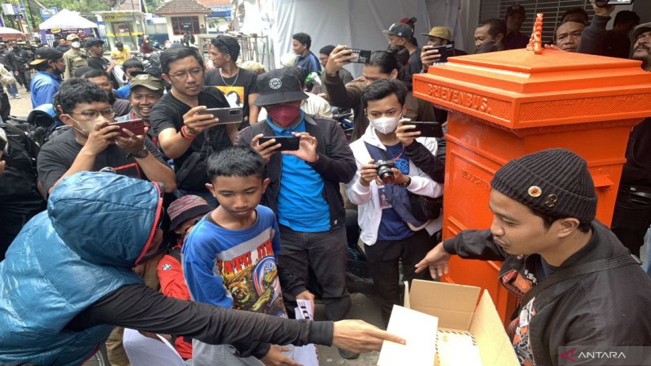 Perwakilan Aremania memasukkan surat yang ditujukan kepada Presiden Joko Widodo ke dalam kotak untuk dikirimkan melalui Kantor Pos Cabang Utama Malang di Kota Malang, Provinsi Jawa Timur, Kamis (17/11/2022). (ANTARA/Vicki Febrianto)