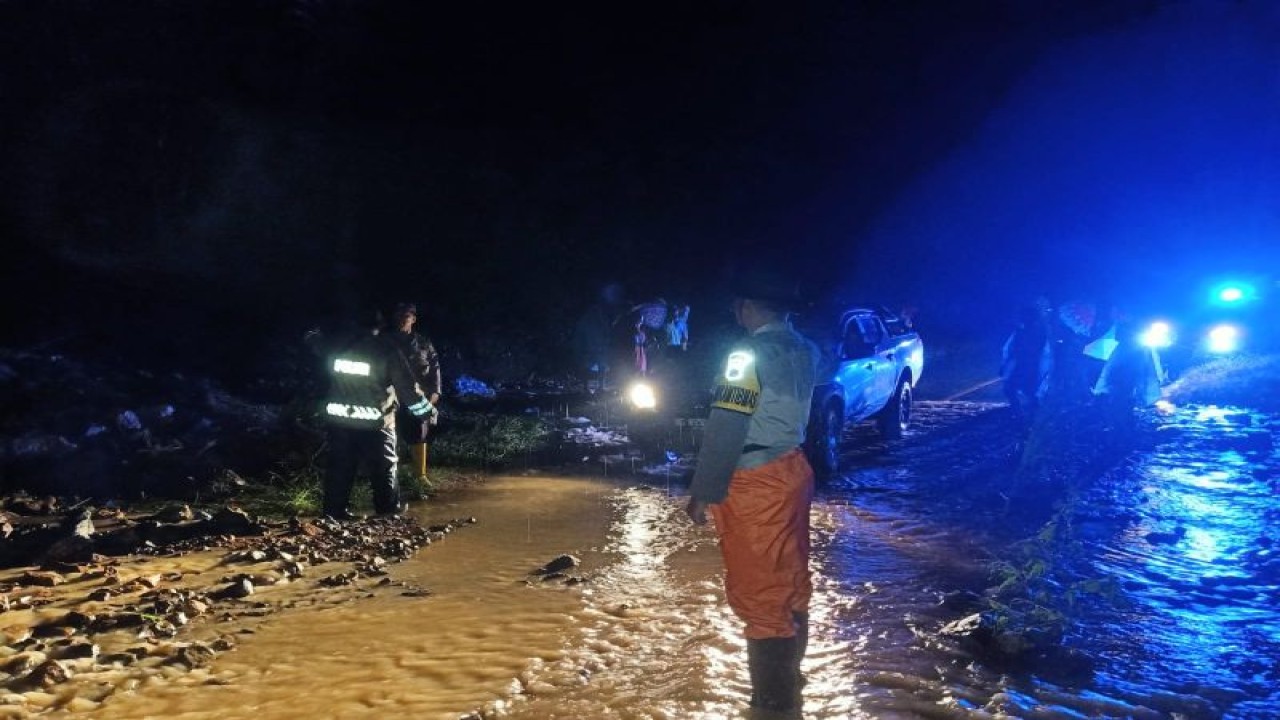 Petugas menyingkirkan material yang menutupi bagian Jalan Trans Flores di Desa Tondong Belang, Kecamatan Mbeliling, Kabupaten Manggarai Barat, Provinsi Nusa Tenggara Timur, akibat banjir yang terjadi pada Sabtu (19/11/2022) malam. (ANTARA/Fransiska Mariana Nuka)