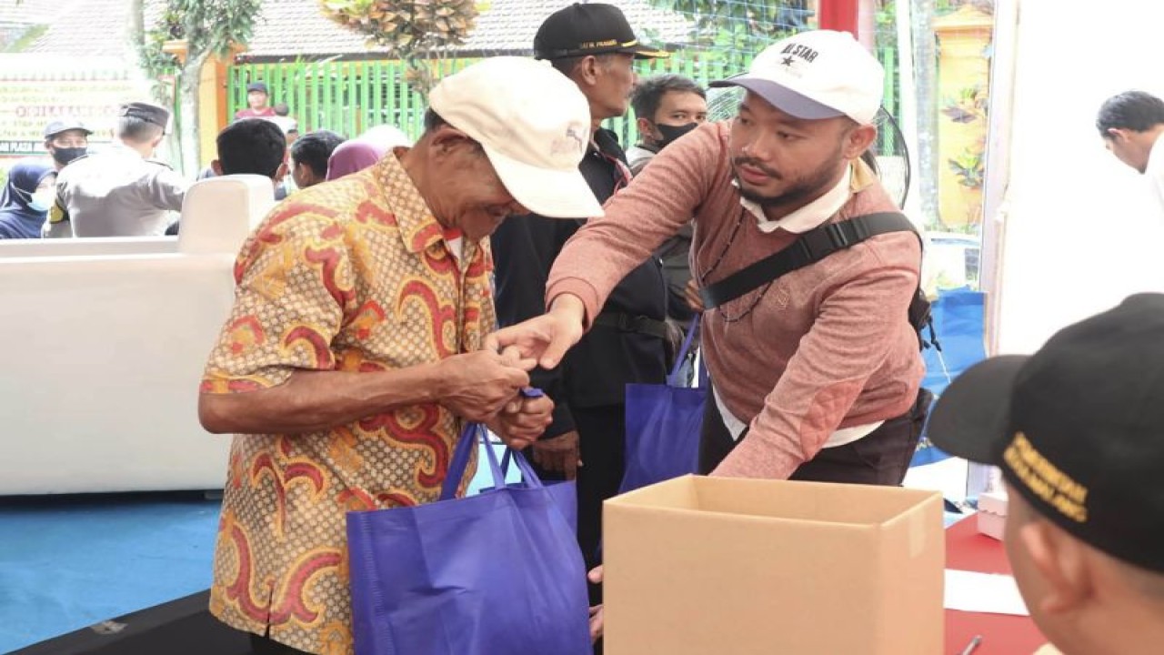 Petugas memberikan paket bahan pokok penting kepada salah satu warga Kelurahan Merjosari, Kecamatan Lowokwaru, pada operasi pasar yang digelar di Kota Malang, Jawa Timur, Selasa (15/11/2022). ANTARA/HO-Humas Pemkot Malang