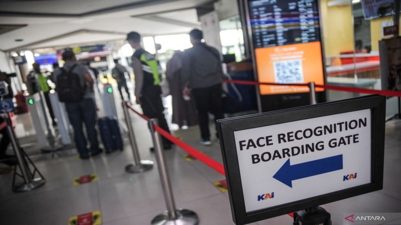 Petugas mengarahkan calon penumpang untuk memindai wajah sebelum memasuki peron Stasiun Bandung, Jawa Barat, Senin (3/10/2022). PT Kereta Api Indonesia (KAI) Persero melakukan uji coba fasilitas "Face Recognition Boarding Gate" atau pemindaian wajah yang ditujukan untuk mempermudah penumpang boarding di stasiun dengan cukup memindai wajah pada alat khusus yang tersedia. ANTARA FOTO/Raisan Al Farisi/rwa. (ANTARA FOTO/RAISAN AL FARISI)