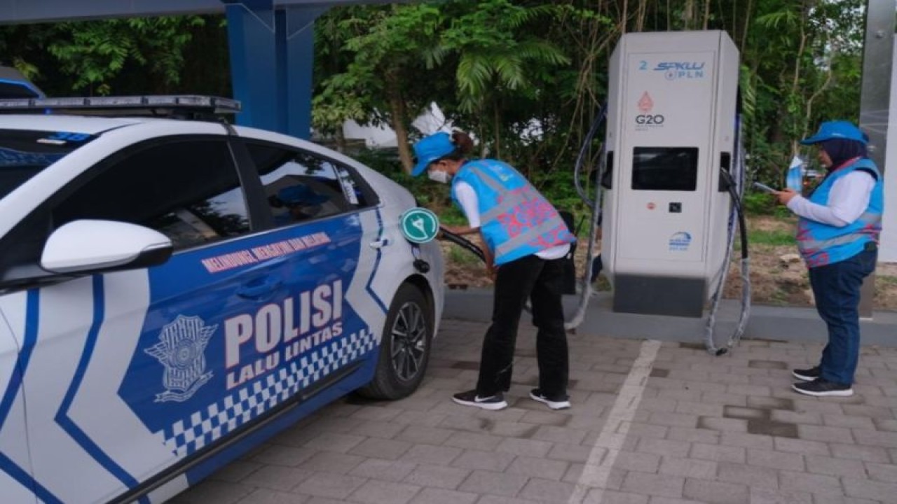 Petugas PLN sedang melakukan pengisian ulang daya baterai mobil listrik milik polisi di Sentral Parkir ITDC Nusa Dua, Badung, Bali, Minggu (13/11/2022). ANTARA/HO-Humas PLN Bali