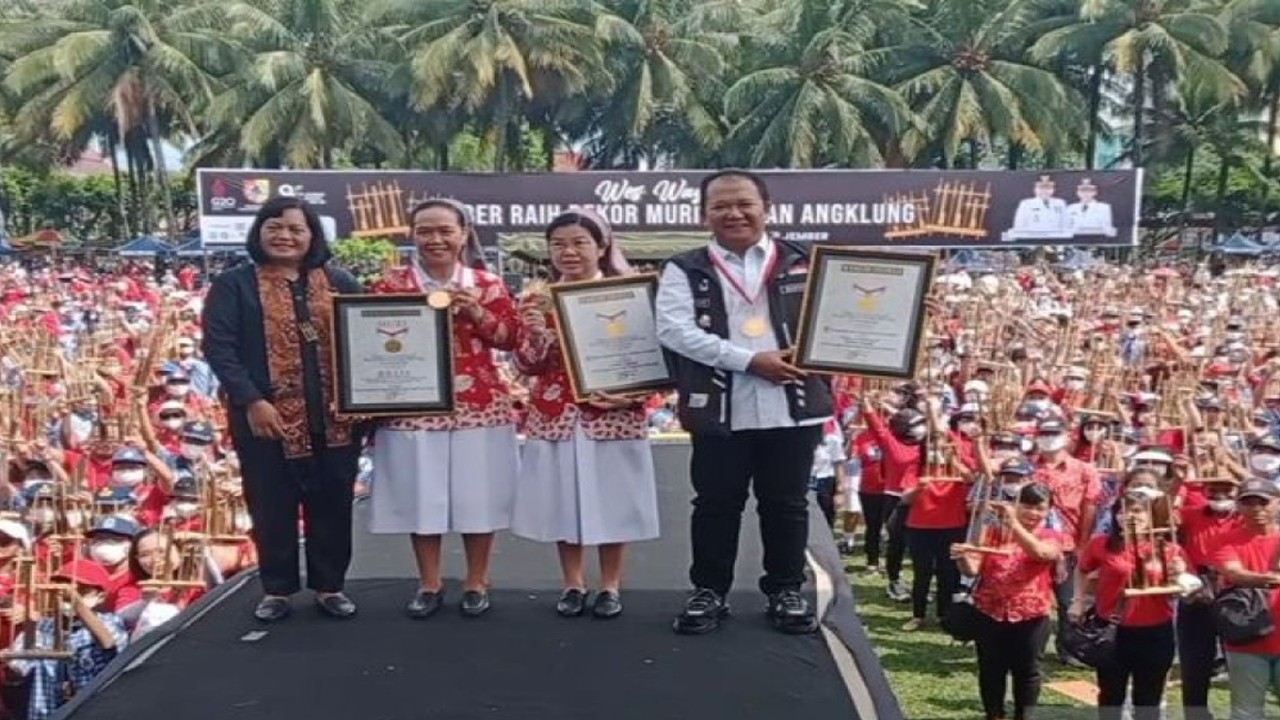 Bupati Jember Hendy Siswanto (kanan) bersama Eksekutif Manager MURI Sri Widayati (kiri) dan penyelenggara usai menerima piagam penghargaan MURI dalam Gebyar Angklung di alun-alun Jember, Rabu (16/11/2022). (ANTARA/Zumrotun Solichah)