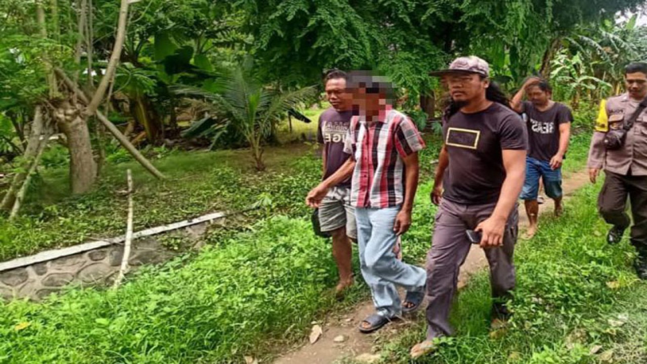 Petugas kepolisian menggiring pelaku rudapaksa terhadap anak kandungnya yang masih belia berinisial IS (kedua kiri) dari tempat persembunyian di wilayah Lape, Sumbawa, NTB, Kamis (24/11/2022). (ANTARA/HO-Polres Dompu)