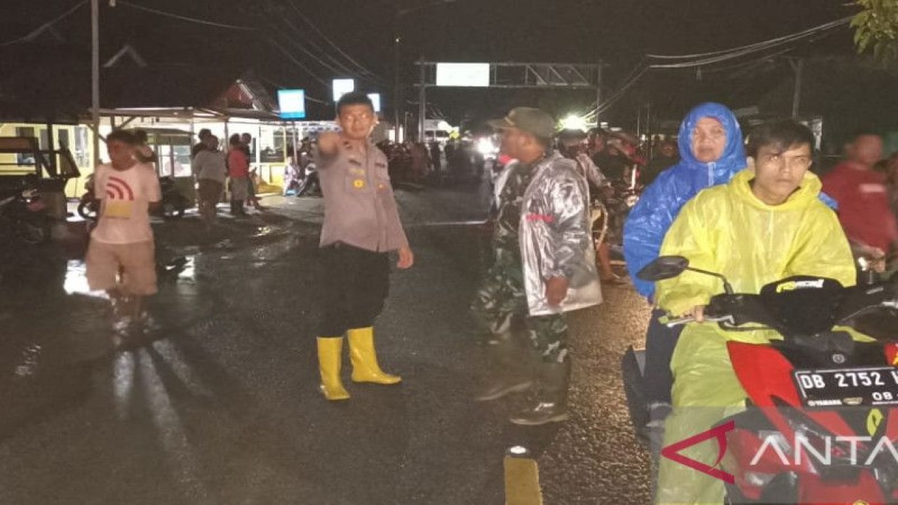 Polres Gorontalo Utara bersama TNI, melakukan pengaturan perlintasan Sulawesi di Desa Jembatan Merah, Kecamatan Tomilito, akibat terdampak banjir sejak Ahad sore (13/11/2022). (ANTARA/Susanti Sako)