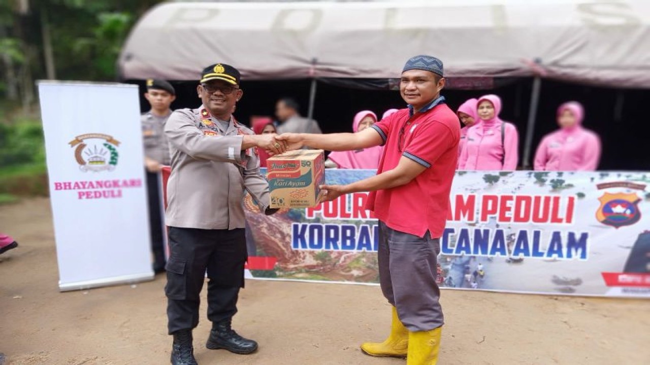 Waka Polres Agam Kompol Andrizal Guci menyerahkan bantuan sembako kepada Wali Jorong Arikia, Epa Candra, Jumat (18/11/2022). (ANTARA/HO-Polres Agam)