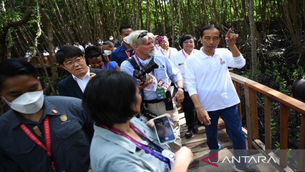 Presiden Joko Widodo (kanan) bersama sejumlah wartawan dalam negeri dan luar negeri mengunjungi kawasan hutan mangrove dalam rangkaian kegiatan KTT G20 di Taman Hutan Raya (Tahura) Ngurah Rai, Denpasar, Bali, Rabu (16/11/2022). ANTARA FOTO/Media Center G20 Indonesia/Galih Pradipta/aww.
