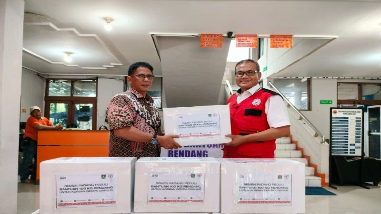 Kepala Departemen Komunikasi dan  Hukum Perusahaan PT Semen Padang Iskandar Z Lubis (kanan) menyerahkan rendang untuk bantuan gempa Cianjur diterima oleh Kasubag Umum BPBD Sumbar Ade Irmansyah  di Padang, Kamis. (Antara/HO-Semen Padang)