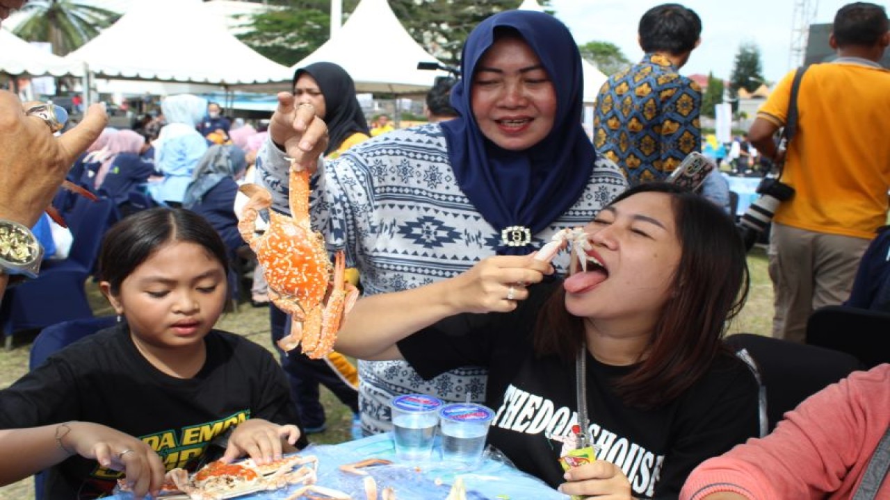 Warga Lampung sedang menikmati rajungan rebus dalam peringatan hari ikan nasional dengan memakan satu ton rajungan di Bandarlampung, Jumat (18/11/2022). ANTARA/Ruth Intan Sozometa Kanafi.