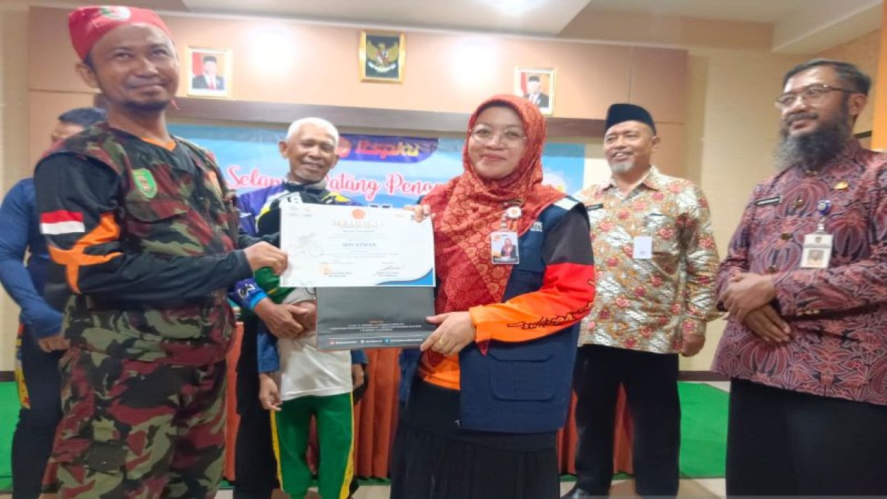 Rektor Institut Teknologi Sains (ITS) dan Kesehatan PKU Muhammadiyah Surakarta Weni Hastuti (kanan) menyerahkan penghargaan kepada seorang pesepeda asal Kalimantan, Rabu (16/11/2022). ANTARA/Bambang Dwi Marwoto.
