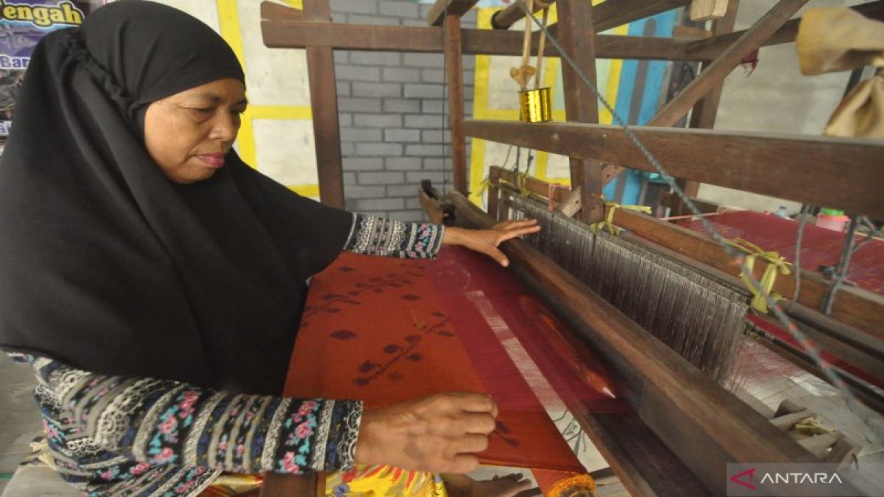 Seorang pekerja sedang menenun kain Donggala khas Sulawesi di rumah produksi kain tenun Donggala di Kota Palu, Provinsi Sulawesi Tengah, Jumat (18/11/2022). ANTARA/Muhammad Izfaldi