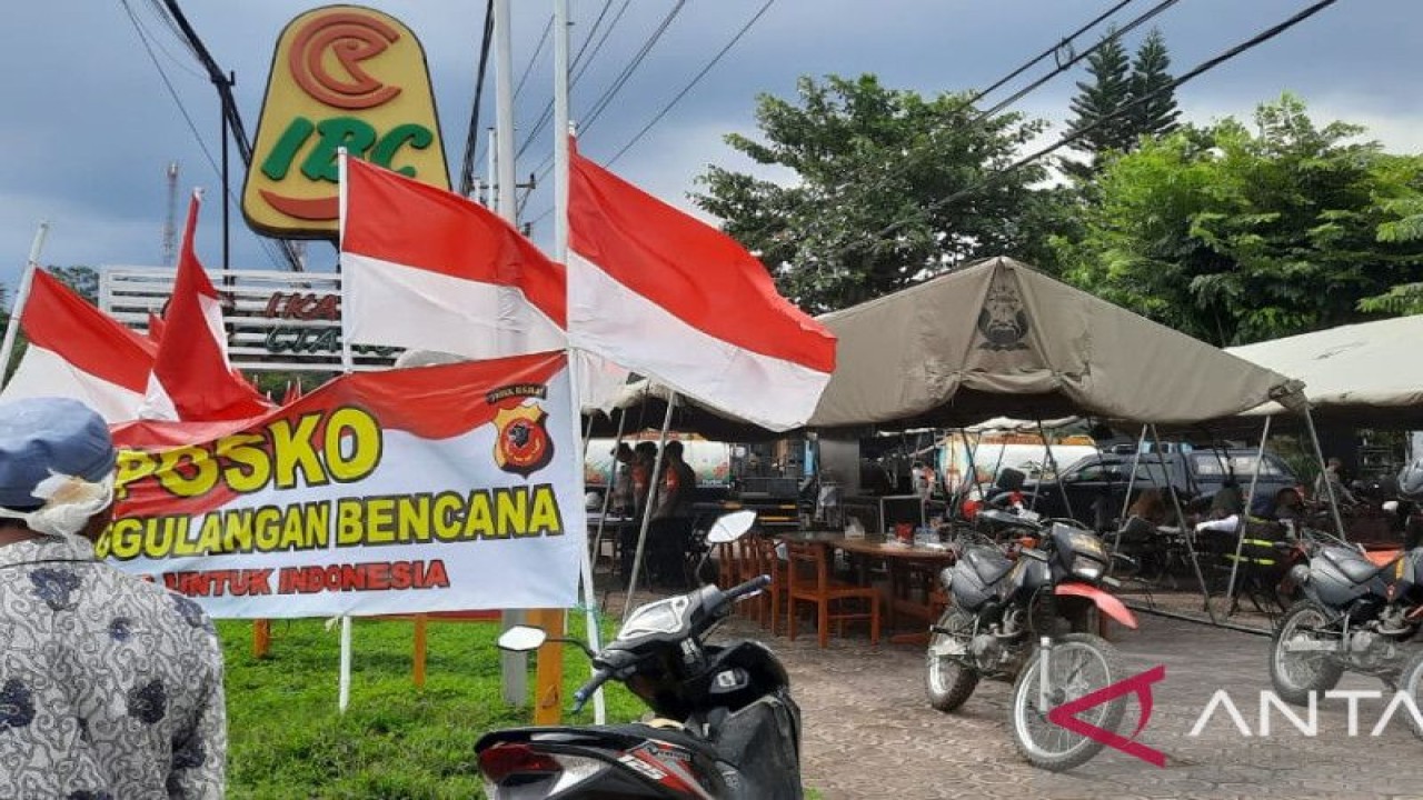 Seorang warga berdiri di depan Posko Penanggulangan Bencana Brimob Polri di Jalan Raya Cipanas-Cianjur, Jawa Barat, Selasa (22/11/2022). ANTARA/Laily Rahmawaty