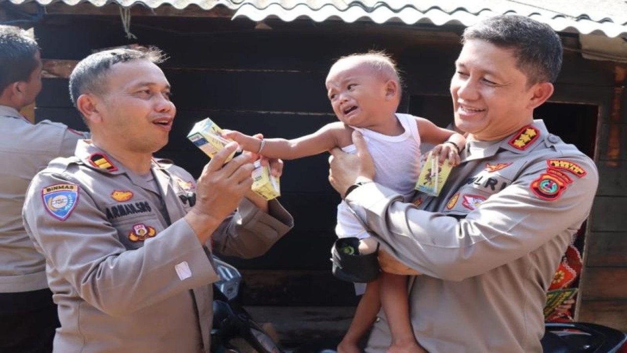 Kapolrestabes Medan Kombes Pol Valentino Alfa Tatareda (kanan) menggendong seorang anak penderita stunting (gizi buruk) di Kelurahan Belawan II, Kota Medan. (Foto:ANTARA/HO)