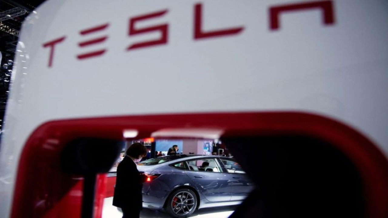 Sebuah kendaraan listrik Tesla terlihat melalui titik pengisian yang ditampilkan selama hari media untuk pameran Auto Shanghai di Shanghai, China 20 April 2021. (Aly Song/Reuters)