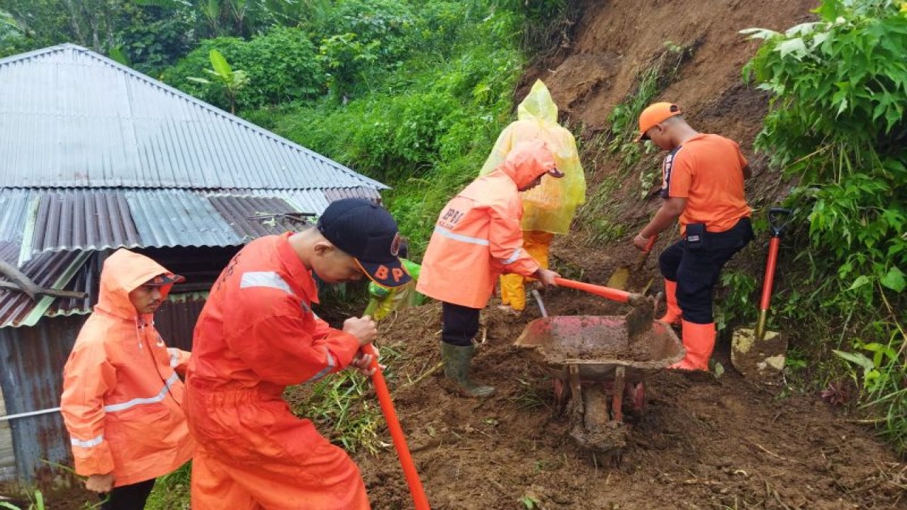 Tim gabungan sedang memberaihkan material longsor mengenai dapur warga di Jorong Pahambatan, Nagari Balingka Kecamatan Ampekkoto, Senin (14/11). (Antara/HO-Dok BPBD Agam)