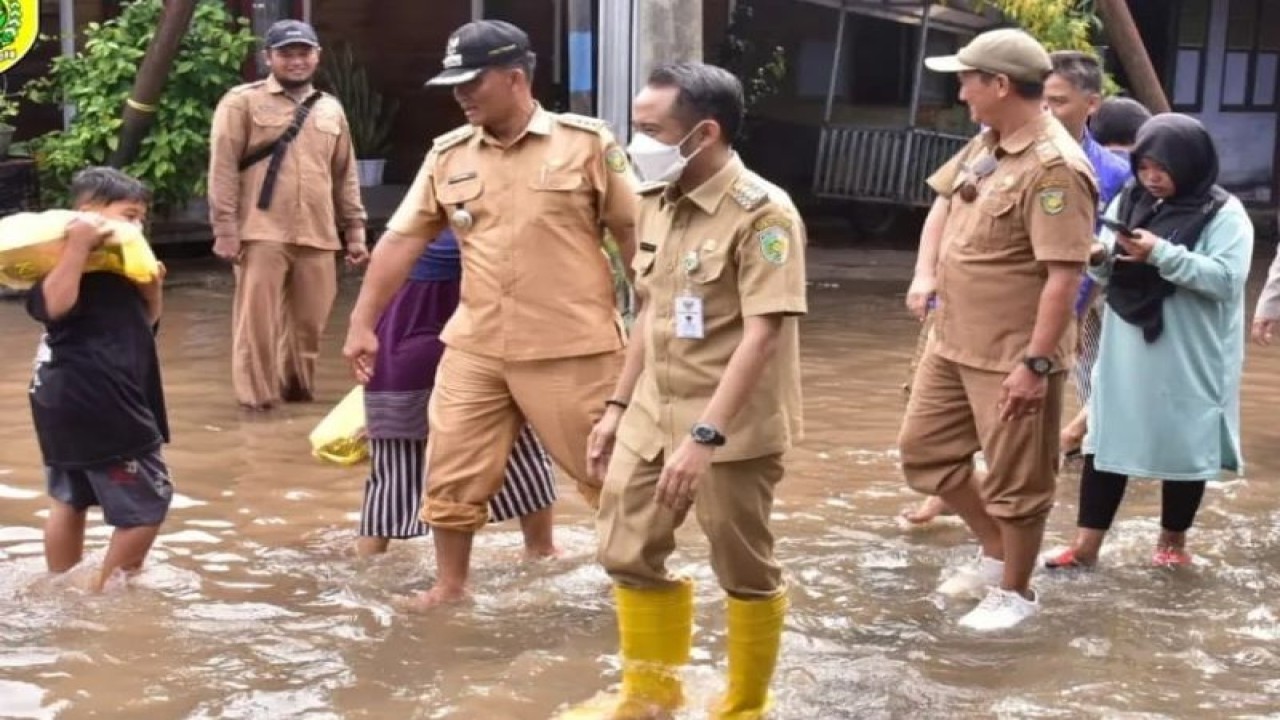 Wali Kota Palangka Raya, Provinsi Kalimantan Tengah Fairid Naparin (sepatu kuning) saat memberikan bantuan kepada masyarakat terdampak banjir di Palangka Raya. (ANTARA/HO-Prokom Palangka Raya)