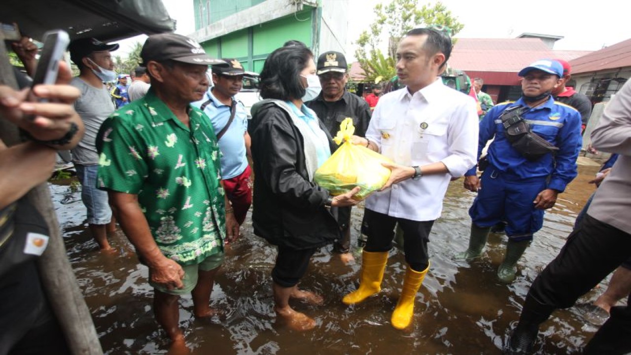 Wali Kota Palangka Raya, Provinsi Kalimantan Tengah, Fairid Naparin (berbaju putih) menyerahkan bantuan paket bahan pangan untuk korban banjir di kota setempat, Rabu (23/11/2022). (ANTARA/M Makna Zaezar)