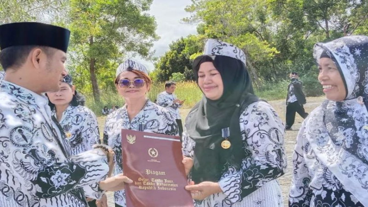 Wali Kota Palangka Raya, Provinsi Kalimantan Tengah Fairid Naparin (kiri) menyerahkan anugerah Satya Lencana pada guru di Palangka Raya, Jumat (25/11/2022). (ANTARA/Dokumentasi Pribadi.)