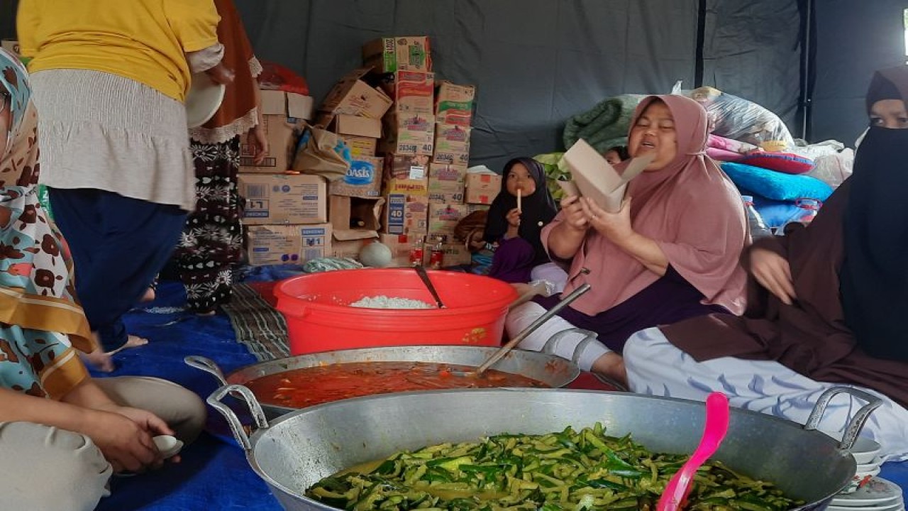 Warga memasukkan hidangan untuk dibagikan kepada pengungsi gempa di Kampung Panyaweuyan, Desa Ciherang, Cianjur, Jawa Barat, Jumat (25/11/2022). (ANTARA/Laily Rahmawaty)