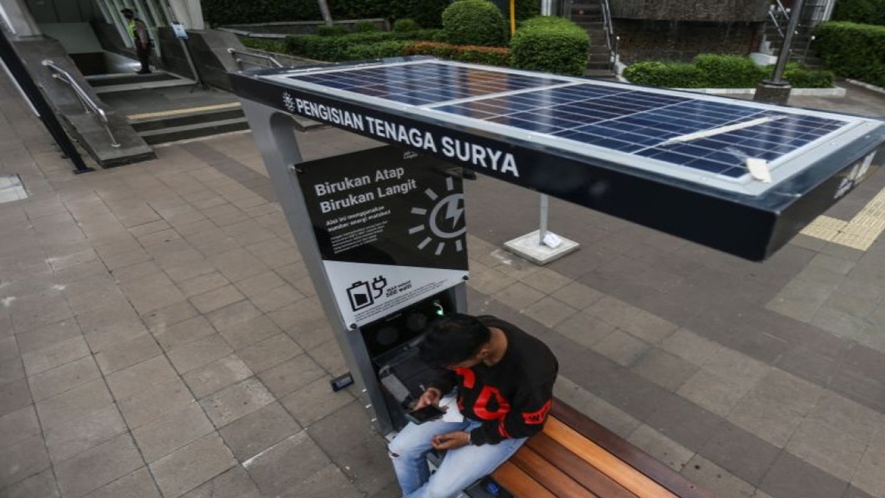 Warga mengisi daya gawainya di stasiun pengisi daya listrik bertenaga surya di kawasan Dukuh Atas, Jakarta, Senin (14/11/2022). ANTARA FOTO/Asprilla Dwi Adha/YU