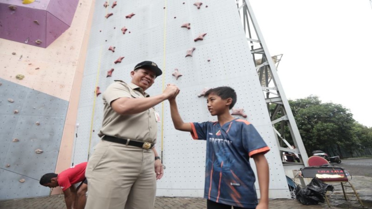 Wali Kota Jakarta Utara Ali Maulana Hakim (kiri) memberi salam komando kepada salah seorang atlet kejuaraan Sirkuit Panjat Tebing tingkat Provinsi DKI Jakarta seri dua 2022 di GOR Rawa Badak, Koja, Jakarta Utara, Senin (26/12/2022). ANTARA/HO-Kominfotik Jakarta Utara