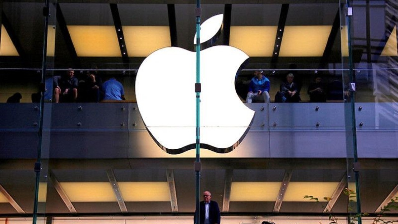 Arsip foto - Seorang pelanggan berdiri di bawah logo Apple yang menyala saat dia melihat ke luar jendela toko Apple yang terletak di pusat Sydney, Australia, 28 Mei 2018. REUTERS/David Gray/pri. (REUTERS/DAVID GRAY)