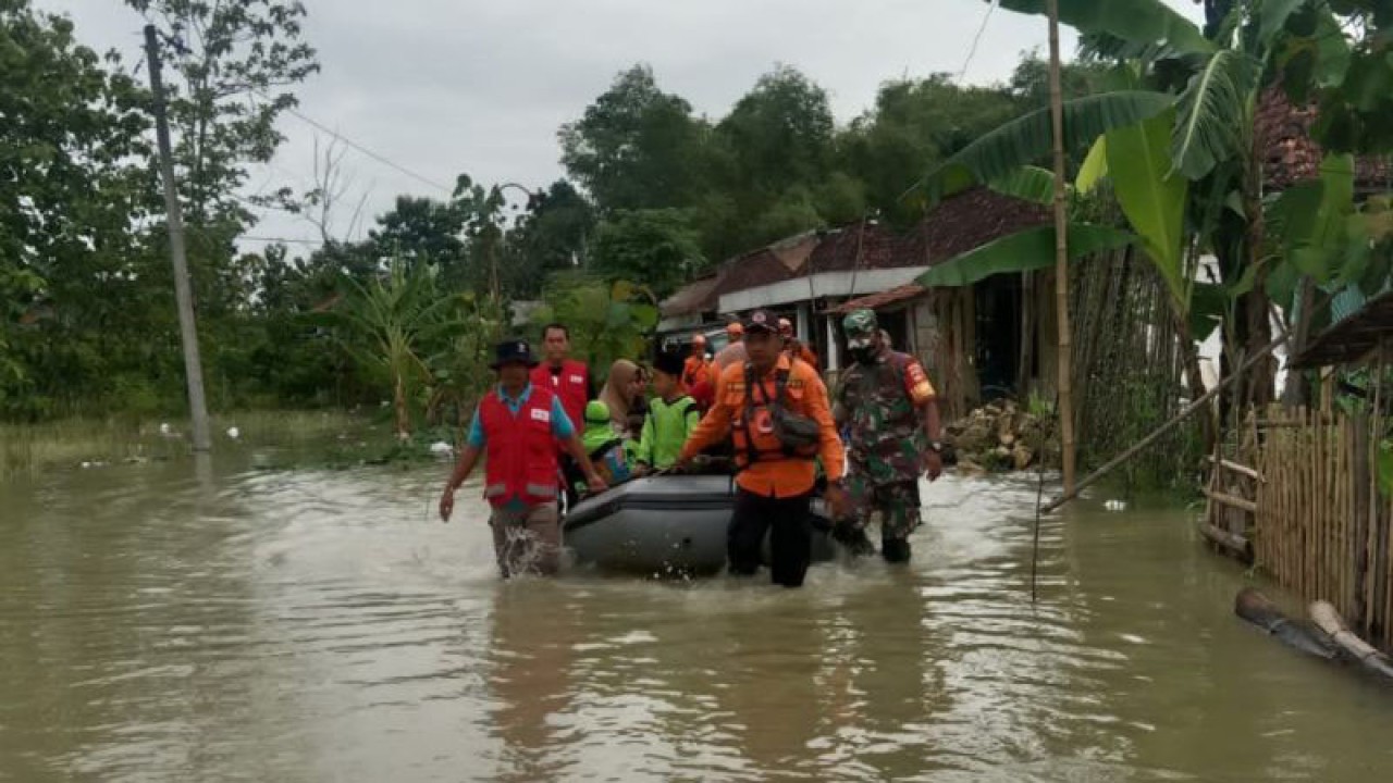 Bantuan penyeberangan bagi warga yang hendak berangkat ke sekolah maupun aktivitas kerja karena akses jalan tergenang banjir, Jumat (2/12/2022). .ANTARA/Akhmad Nazaruddin Lathif.