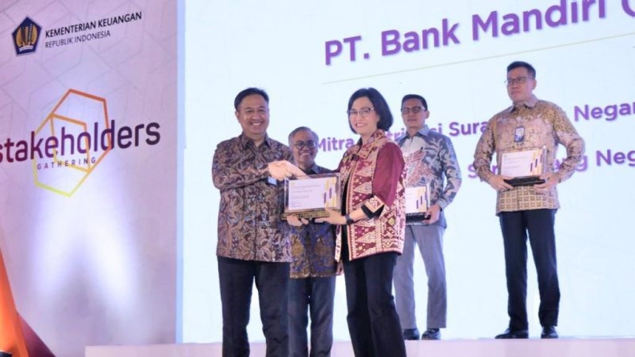 Direktur Treasury & International Banking Bank Mandiri Panji Irawan (kiri) menerima penghargaan sebagai Dealer Utama SUN dengan Kinerja Terbaik dan Mitra Distribusi SUN Ritel dengan Kinerja Terbaik untuk periode 2022 dari Menkeu Sri Mulyani pada acara Stakeholders Gathering Direktorat Jenderal Pengelolaan Pembiayaan dan Risiko (DJPPR) Tahun 2022 di Jakarta, Rabu (21/12/2022). ANTARA/HO-BankMandiri/pri.