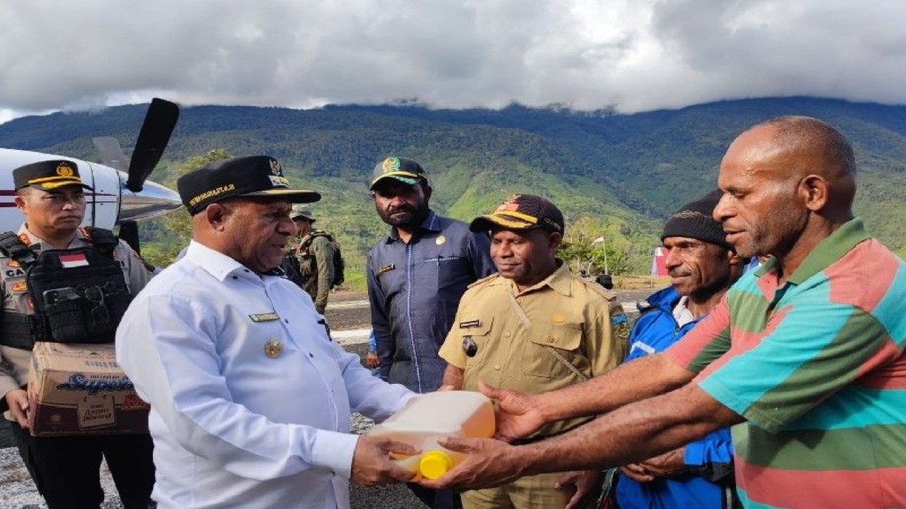 Bupati Pegunungan Bintang Yan Spei Bidana menyerahkan bantuan kepada warga Kiwirok. (ANTARA/HO-Polres Pegunungan Bintang)