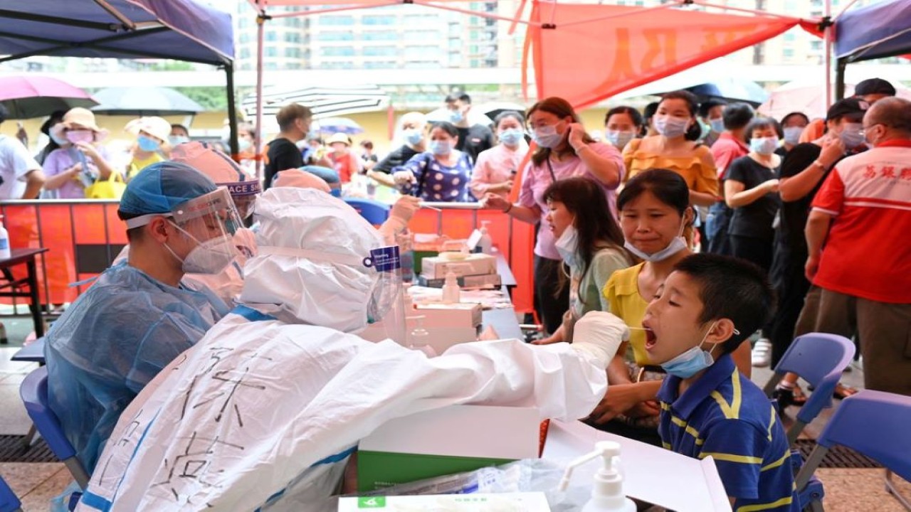 Seorang pekerja medis mengambil swab dari seorang warga selama pengujian massal untuk penyakit virus corona (Covid-19) di tempat pengujian darurat di sebuah stadion di Guangzhou, provinsi Guangdong, China, pada 30 Mei 2021. (Reuters)