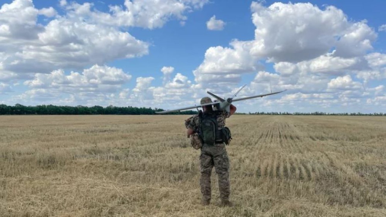 Seorang anggota tim pengawasan militer Ukraina bersiap meluncurkan drone dari ladang gandum di Ukraina selatan. (Jason Beaubien/NPR)