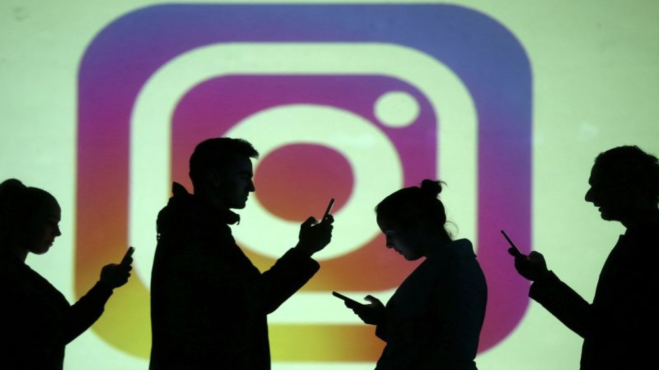 FILE PHOTO: Silhouettes of mobile users are seen next to a screen projection of Instagram logo in this picture illustration taken March 28, 2018. REUTERS/Dado Ruvic/Illustration (REUTERS/Dado Ruvic)