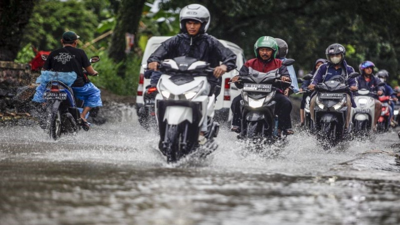 Pengendara melintasi jalan yang tergenang saat hujan di Jalan Raya Bojonggede, Kabupaten Bogor, Jawa Barat, Kamis (17/11/2022). ANTARA FOTO/Yulius Satria Wijaya./hp. (ANTARA FOTO/YULIUS SATRIA WIJAYA)