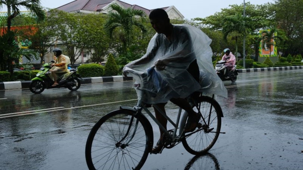 Arsip Foto. Seorang pengendara sepeda melintasi jalanan yang basah saat hujan turun di Kota Pontianak, Provinsi Kalimantan Barat, Senin (21/11/2022). (ANTARA FOTO/JESSICA HELENA WUYSANG)