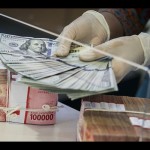 Ilustrasi: Petugas bank sedang menghitung uang dolar AS di bawah tumpukan rupiah di Jakarta. ANTARA FOTO/Rivan Awal Lingga/tom.-1670923966